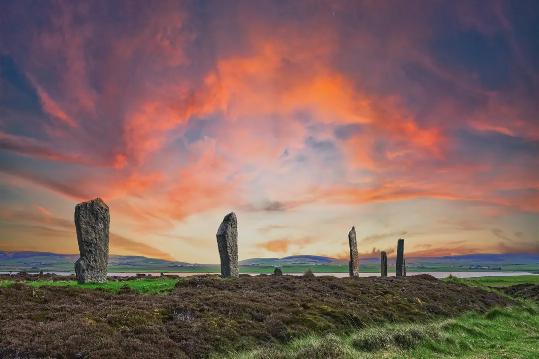 Standing stones of the Ring of Brodgar in Orkney silhouetted against a red evening sky